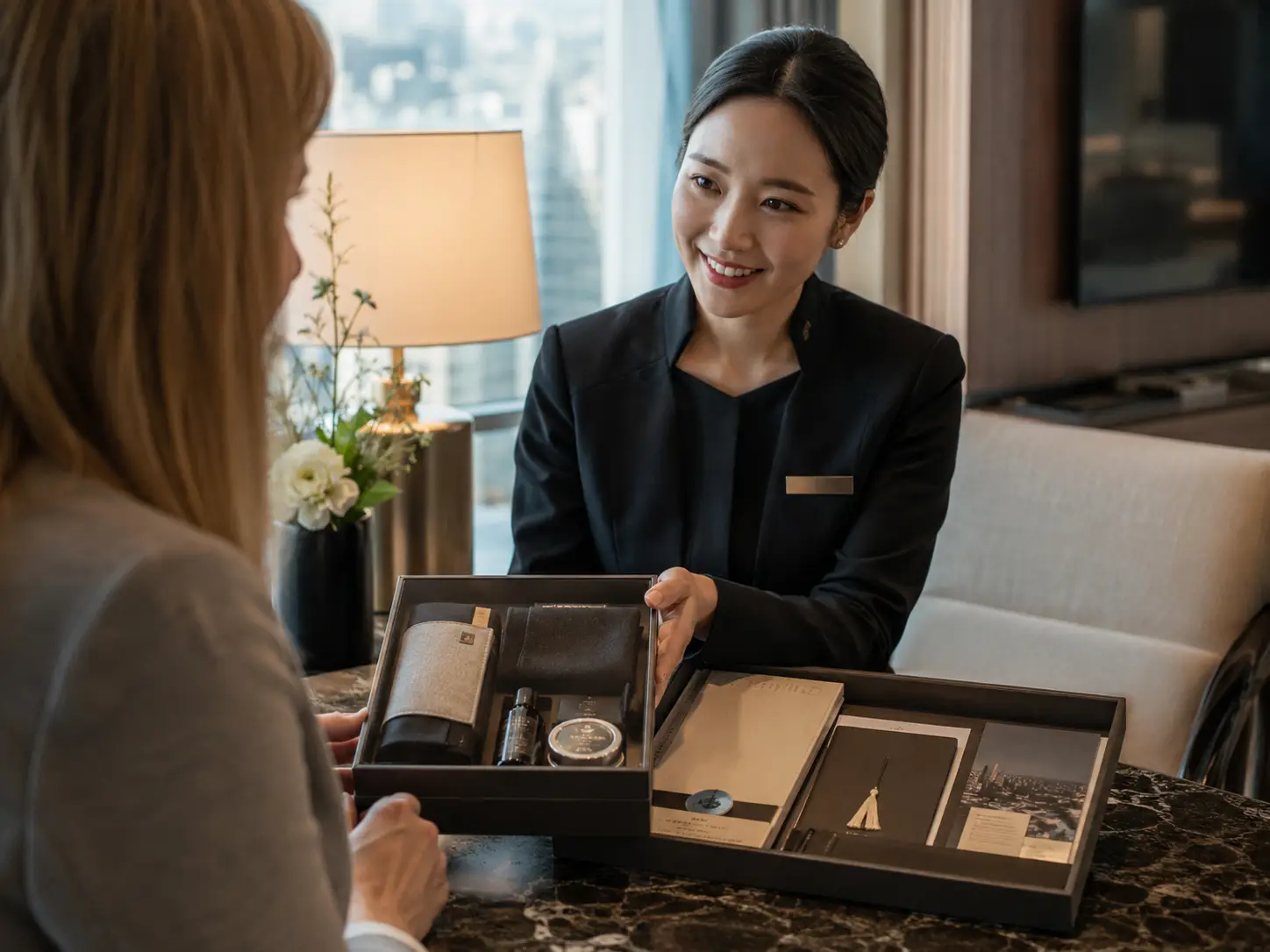 A concierge handing a welcome kit to a participant in a hotel lounge
